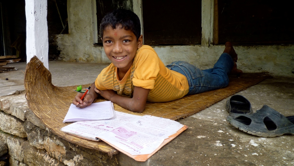 Nepalees jongetje in de bergen huiswerk maken