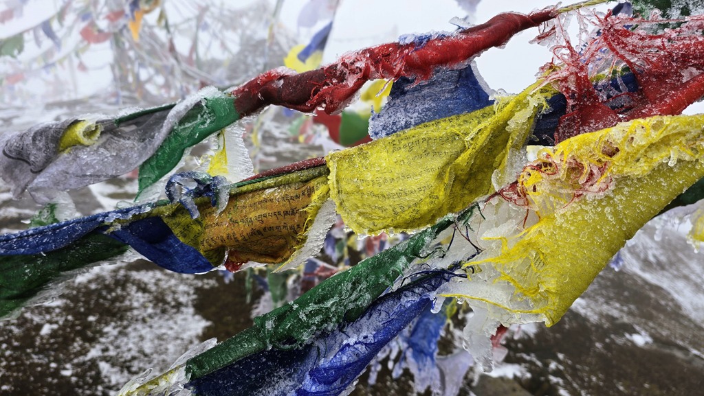 Tibetaanse gebedsvlaggetjes ijs sneeuw kou
